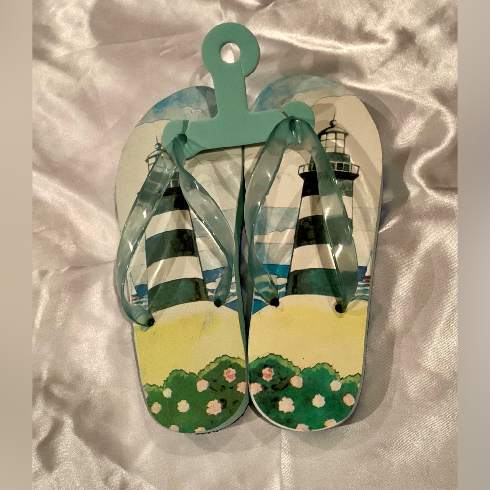 NWOT Unique Lighthouse Print Flip Flops with sand imprint. Size 7
